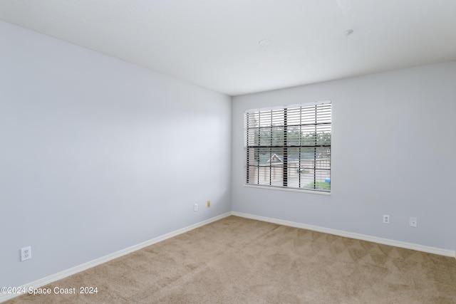 spare room featuring light colored carpet