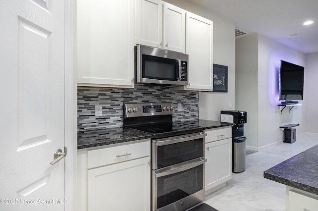 kitchen featuring stainless steel appliances, white cabinets, and tasteful backsplash