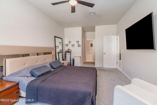 carpeted bedroom featuring ensuite bath, a textured ceiling, and ceiling fan