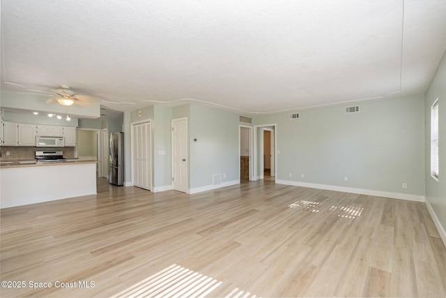 unfurnished living room featuring ceiling fan and light hardwood / wood-style flooring