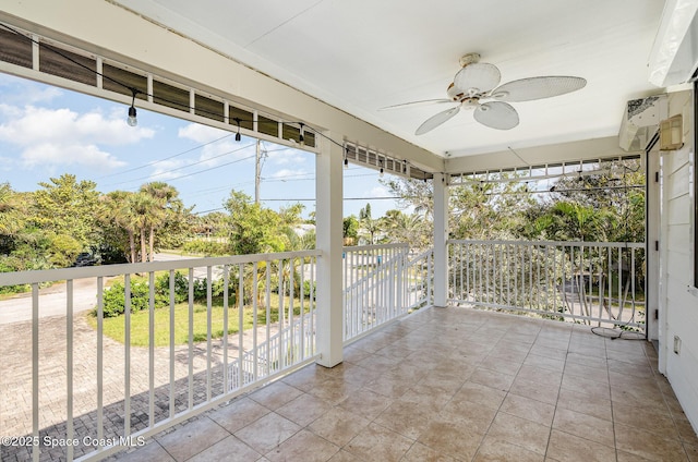 unfurnished sunroom with ceiling fan