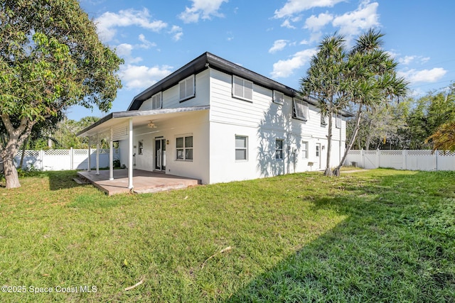 rear view of property featuring a yard, a patio, and ceiling fan