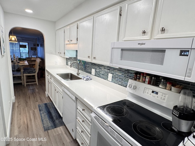 kitchen featuring sink, white appliances, white cabinets, and light hardwood / wood-style flooring