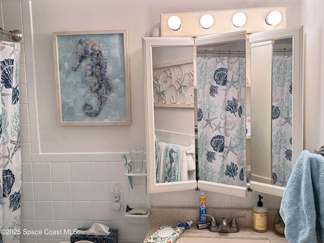 bathroom featuring tile walls and sink