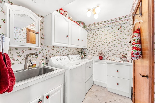 clothes washing area with washing machine and clothes dryer, sink, light tile patterned floors, and cabinets