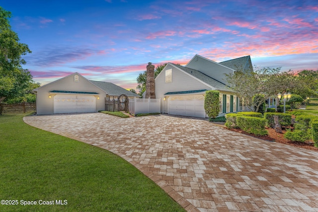 view of front of property with a garage and a lawn