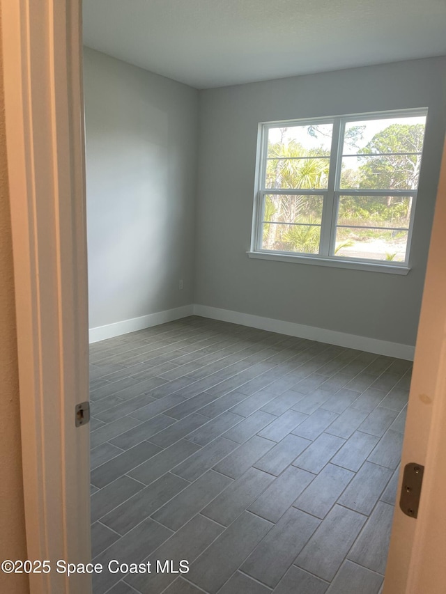 unfurnished room with dark hardwood / wood-style flooring and a healthy amount of sunlight