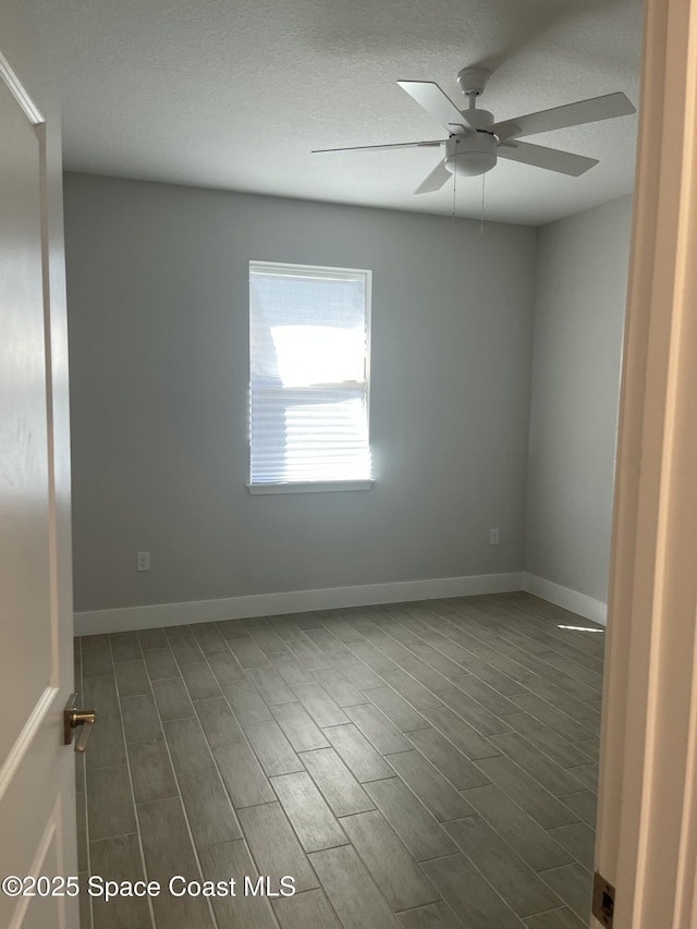 unfurnished room featuring ceiling fan, dark hardwood / wood-style floors, and a textured ceiling