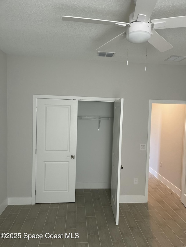 unfurnished bedroom featuring ceiling fan, a closet, and a textured ceiling