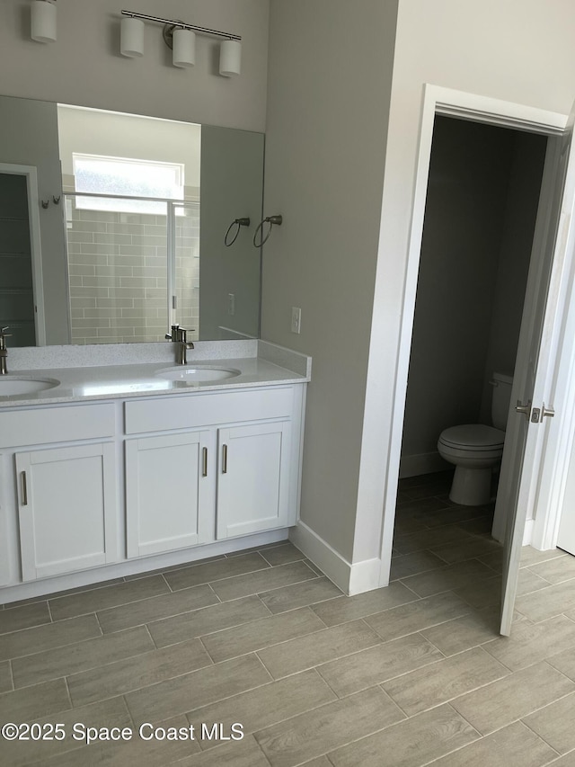 bathroom with vanity, toilet, and an enclosed shower