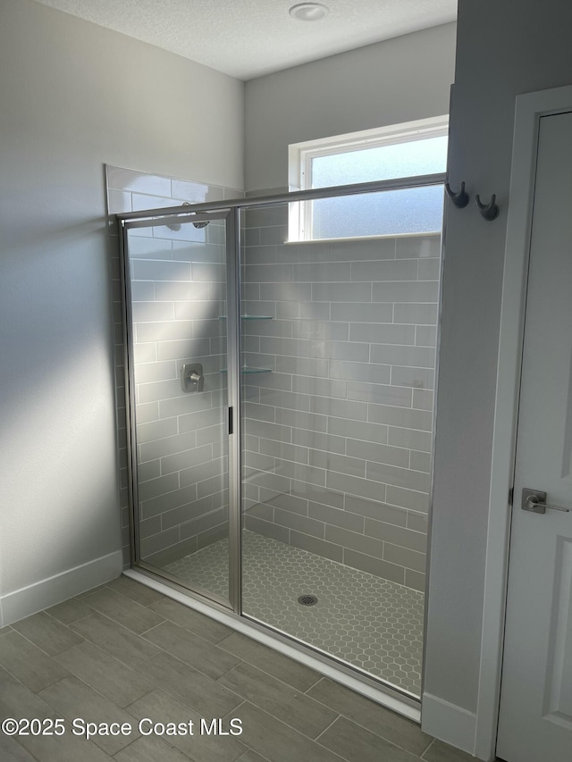 bathroom with an enclosed shower and a textured ceiling