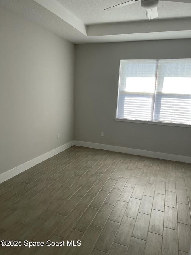 spare room with ceiling fan, wood-type flooring, and a textured ceiling