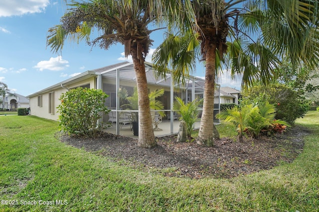 view of property exterior featuring a yard, a patio, and a lanai