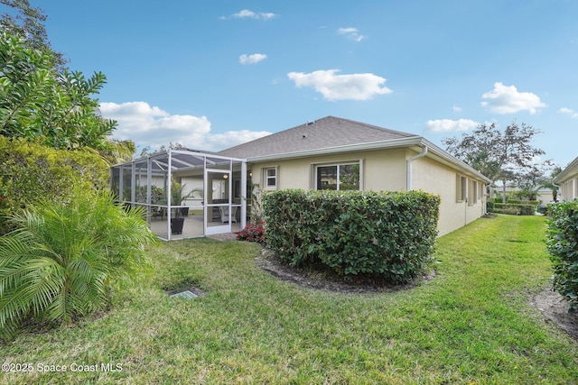 back of house featuring a lawn and a lanai