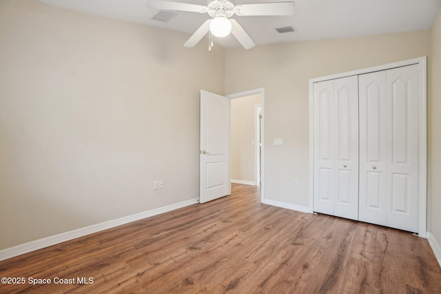 unfurnished bedroom with ceiling fan, light hardwood / wood-style flooring, and a closet