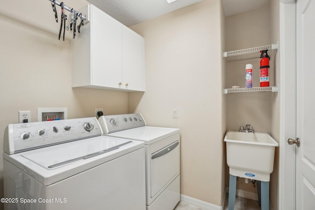 washroom featuring washing machine and dryer, sink, and cabinets