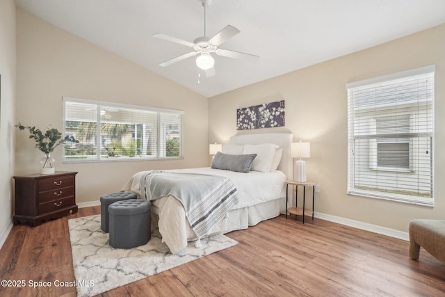 bedroom featuring ceiling fan, light hardwood / wood-style flooring, and lofted ceiling