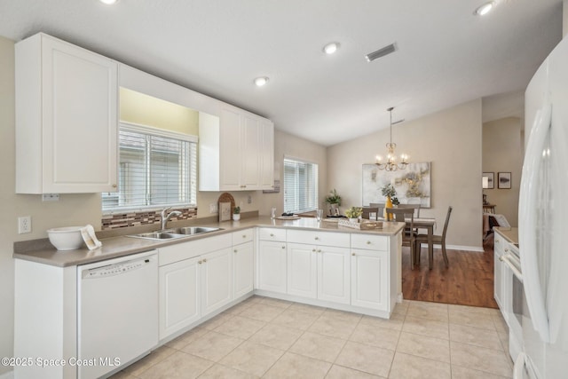 kitchen featuring kitchen peninsula, white cabinetry, white appliances, and sink