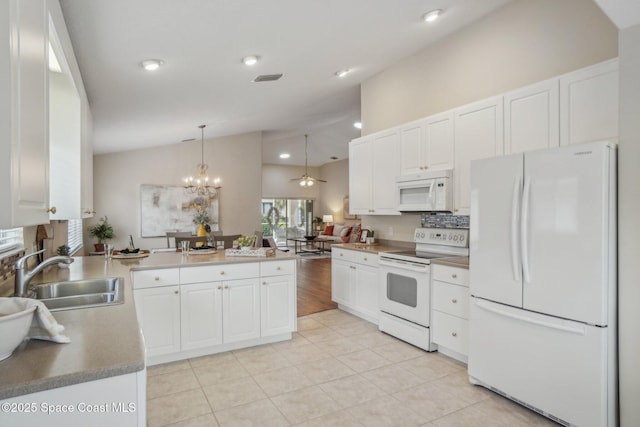 kitchen featuring white appliances, white cabinetry, hanging light fixtures, and vaulted ceiling