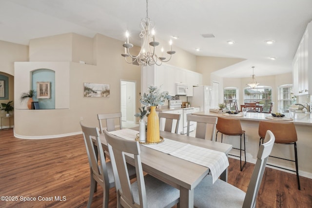 dining space with sink, a chandelier, and dark hardwood / wood-style floors