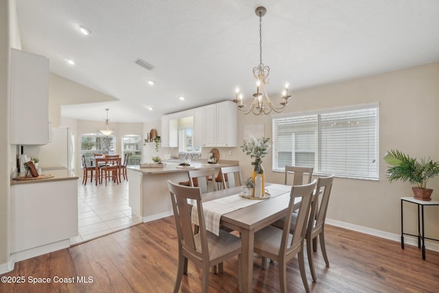 dining room with light wood-type flooring and a notable chandelier