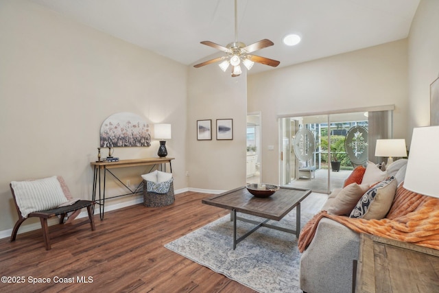 living room with ceiling fan and dark wood-type flooring