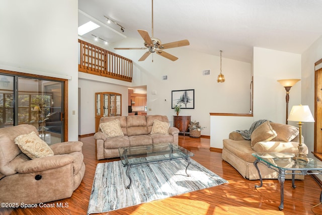 living room with wood-type flooring, vaulted ceiling, and ceiling fan