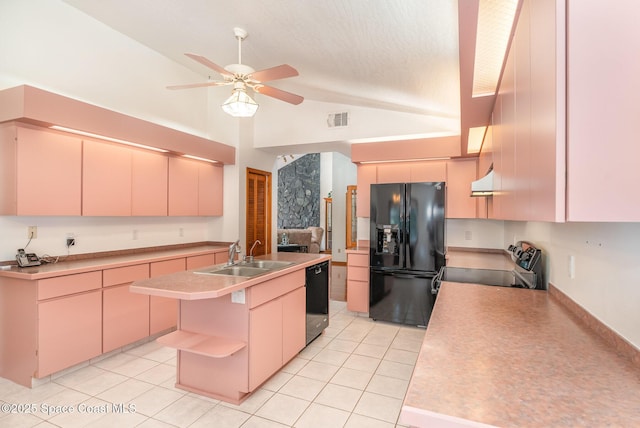 kitchen featuring a center island with sink, black appliances, sink, light tile patterned floors, and light brown cabinetry