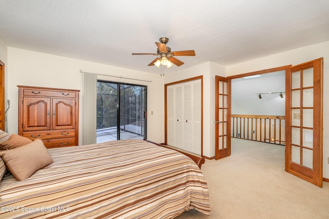 carpeted bedroom featuring access to exterior, french doors, a closet, and ceiling fan