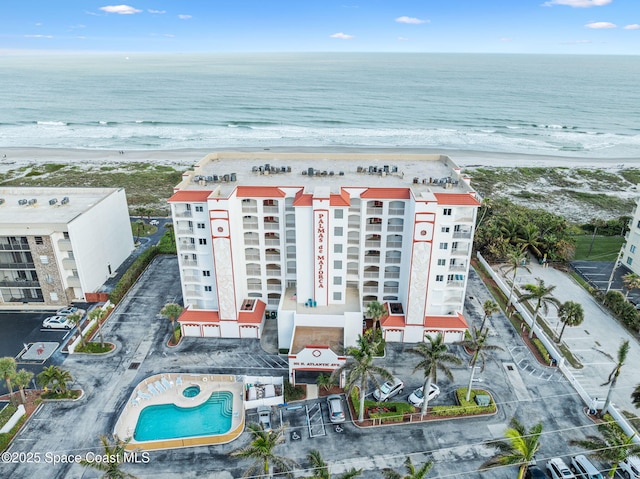 birds eye view of property featuring a water view and a beach view