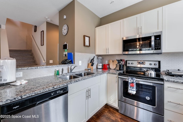 kitchen featuring white cabinetry, sink, light stone countertops, and appliances with stainless steel finishes