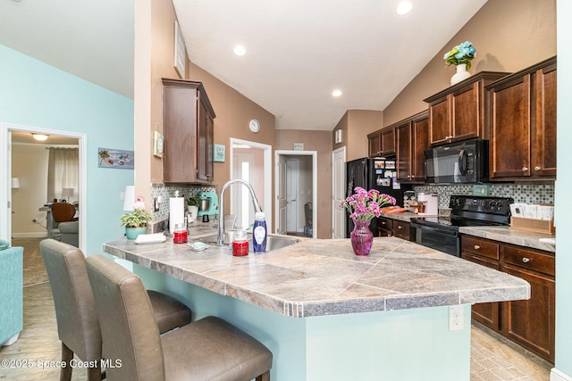 kitchen featuring sink, tasteful backsplash, vaulted ceiling, and black appliances