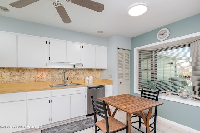 kitchen with tasteful backsplash, stainless steel dishwasher, sink, white cabinetry, and light tile patterned flooring