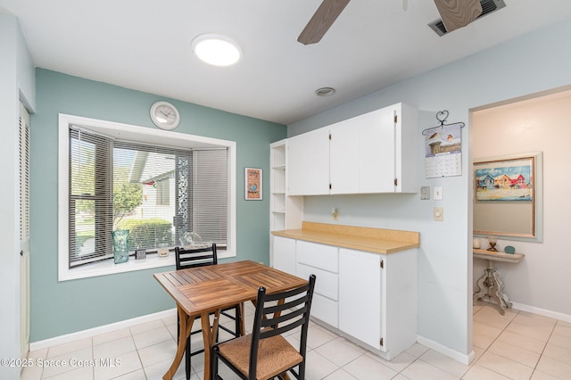 kitchen featuring white cabinets, ceiling fan, and light tile patterned flooring