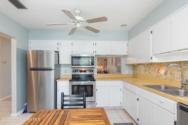 kitchen with white cabinets, sink, ceiling fan, light tile patterned flooring, and stainless steel appliances