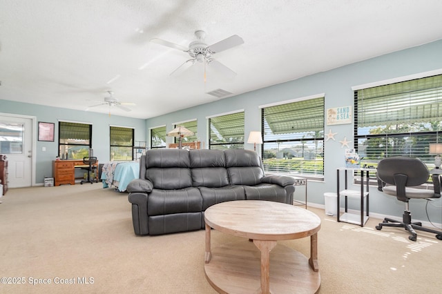 carpeted living room with ceiling fan and a textured ceiling