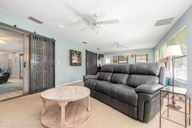 carpeted living room featuring a textured ceiling and ceiling fan