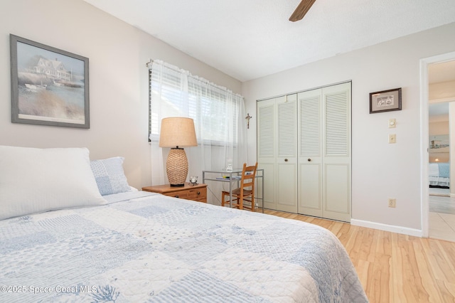 bedroom with ceiling fan, a closet, and light hardwood / wood-style floors