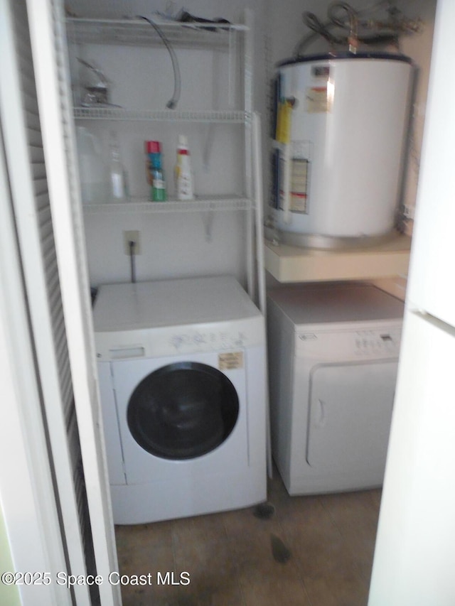 laundry area featuring tile patterned floors, electric water heater, and independent washer and dryer