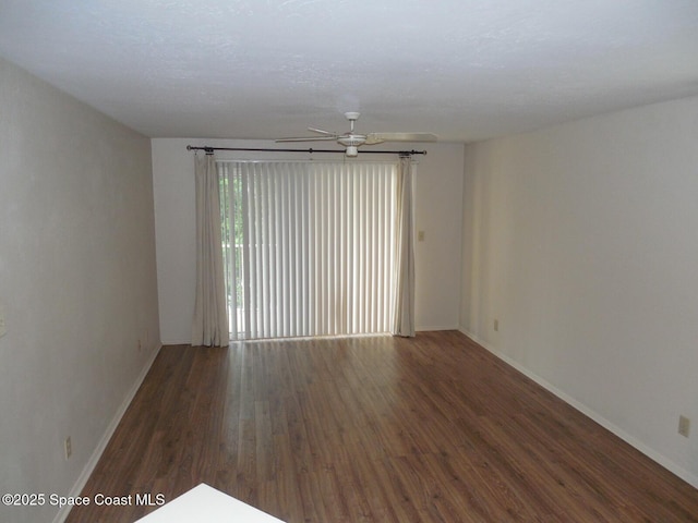 spare room featuring ceiling fan and dark hardwood / wood-style flooring