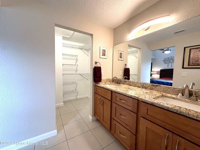 bathroom featuring ceiling fan, a textured ceiling, vanity, and tile patterned flooring