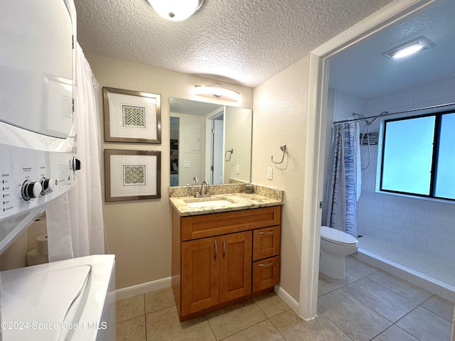 bathroom with toilet, vanity, tile patterned flooring, a textured ceiling, and a shower with shower curtain