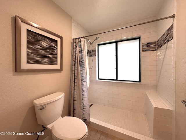 bathroom featuring toilet, a textured ceiling, tile patterned floors, and curtained shower