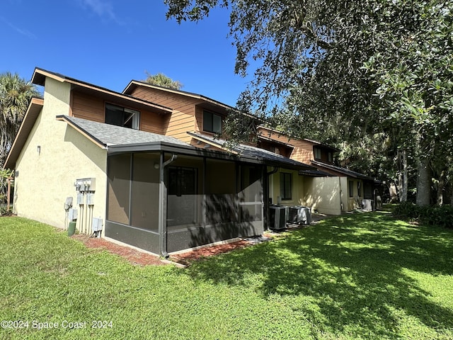 back of property with a lawn, central AC, and a sunroom