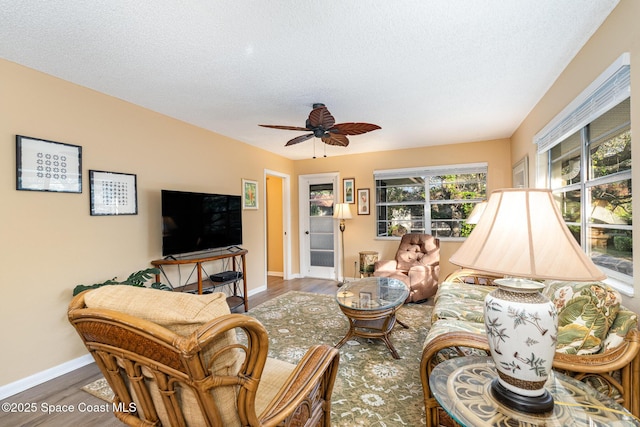 living room featuring hardwood / wood-style floors, a textured ceiling, and ceiling fan