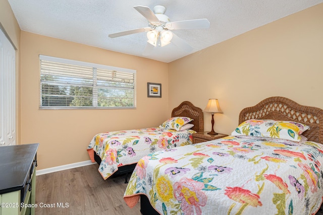 bedroom with a textured ceiling, dark hardwood / wood-style flooring, a closet, and ceiling fan