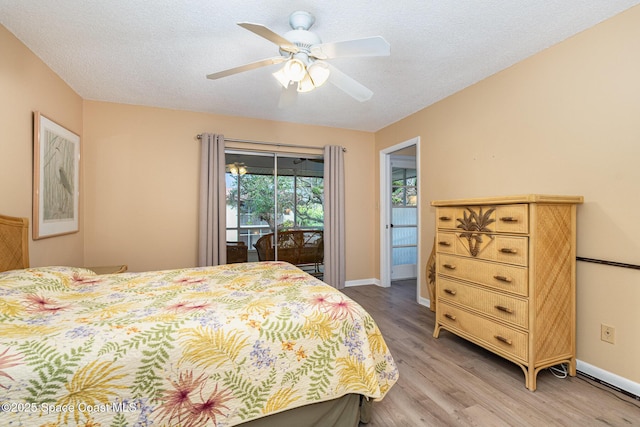 bedroom featuring access to exterior, ceiling fan, light hardwood / wood-style flooring, and a textured ceiling