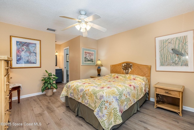 bedroom with wood-type flooring, a textured ceiling, and ceiling fan