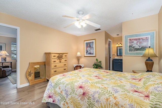 bedroom with connected bathroom, ceiling fan, and hardwood / wood-style flooring