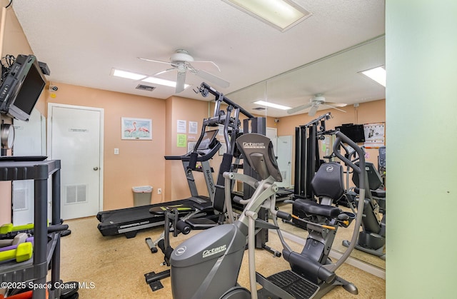 exercise room with ceiling fan and a textured ceiling